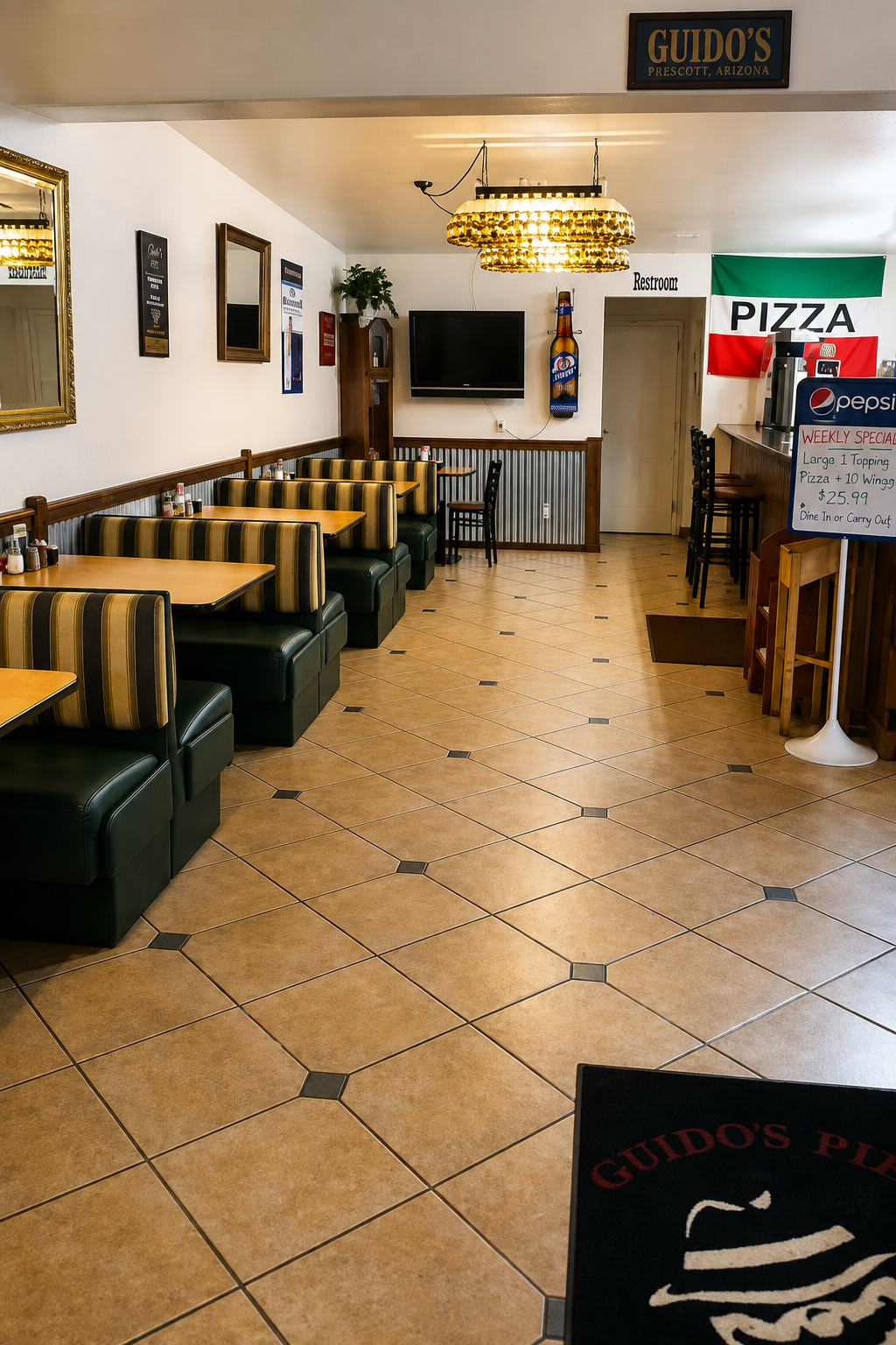The dining room at Guido's Pizza, with booth seating and an Italian flag